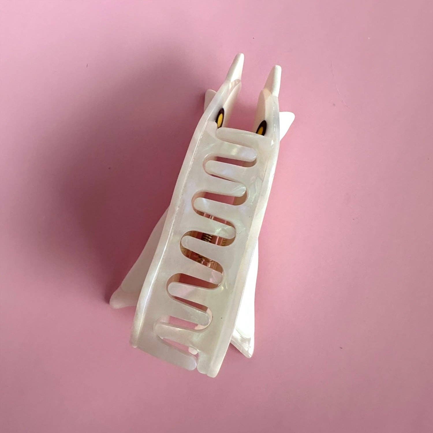 White ghost hair clip on a pink background