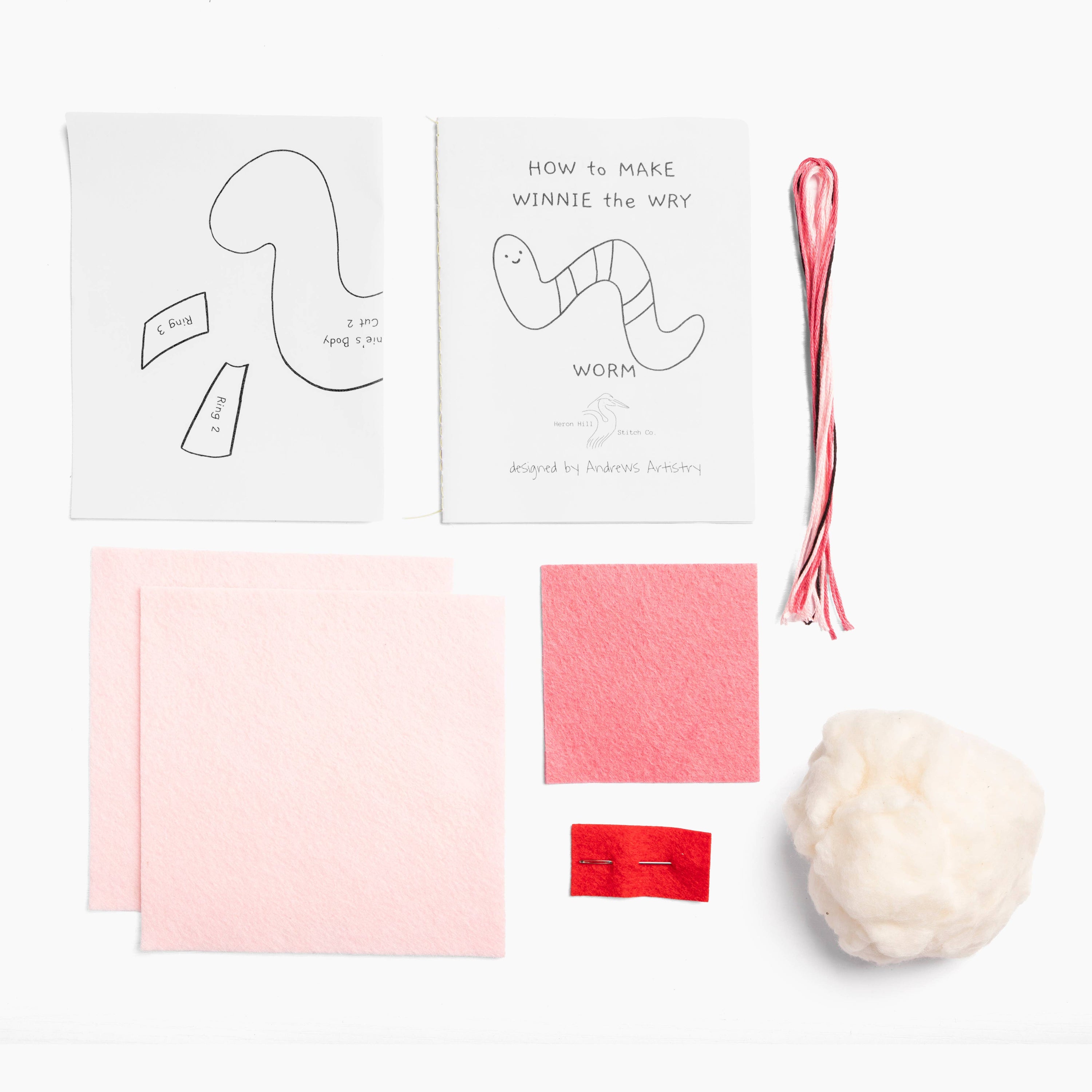 Crafting kit with templates, yarn, and other materials on a white background