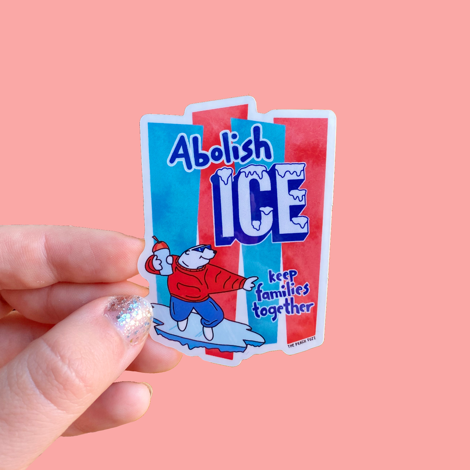 Sticker with 'Abolish ICE' text held by a hand on a pink background