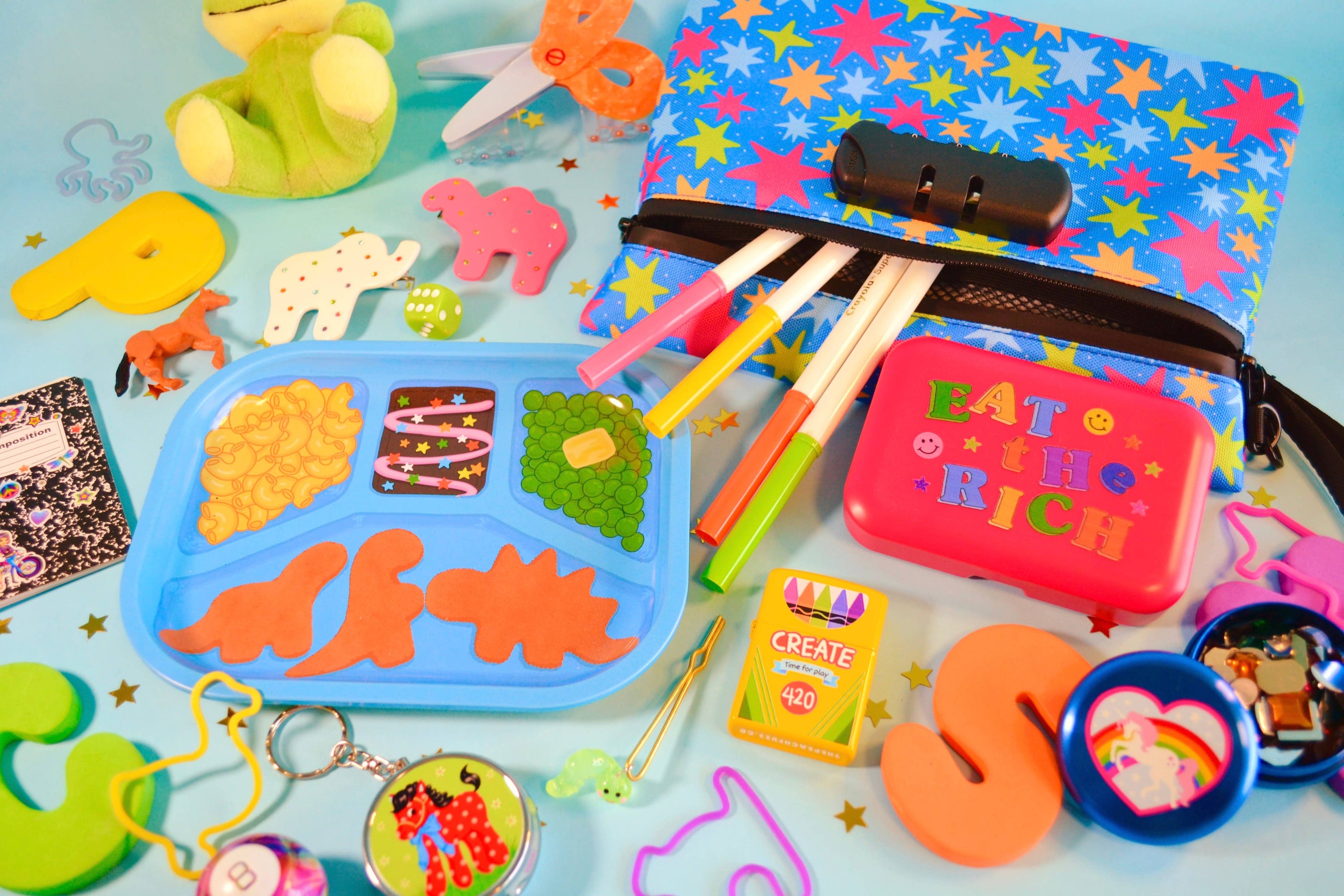 Assorted crafting items and stationery items on a colorful background with the frozen TV dinner and cosmic brownie - dinosaur chicken nuggets included