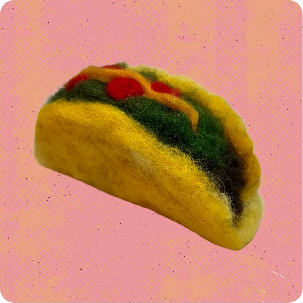 Felt taco toy on a pink background