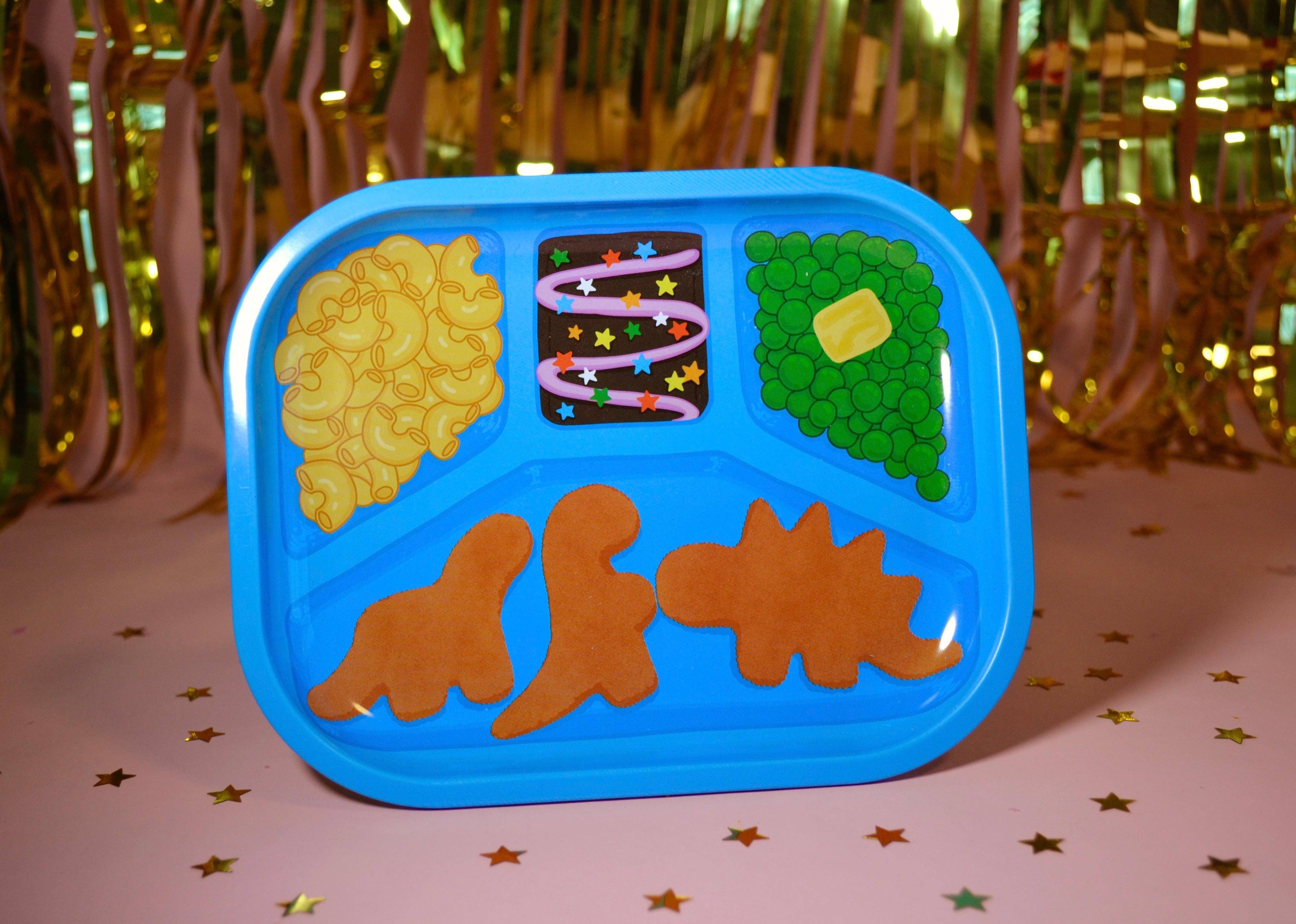 TV Dinner retro blue tray with dinosaur chicken nuggets, mac and cheese and cosmic brownie illustrations shaped on a festive background