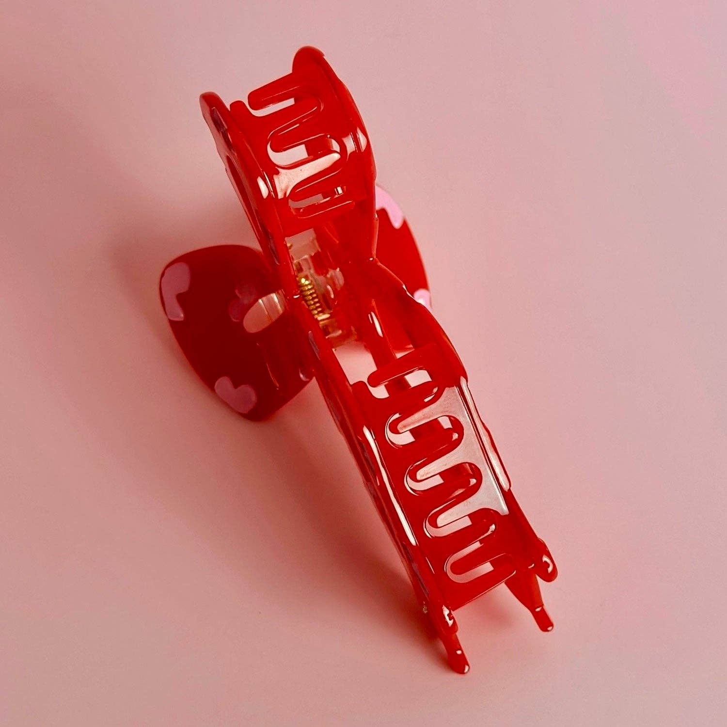 Red hair clip on a pink background