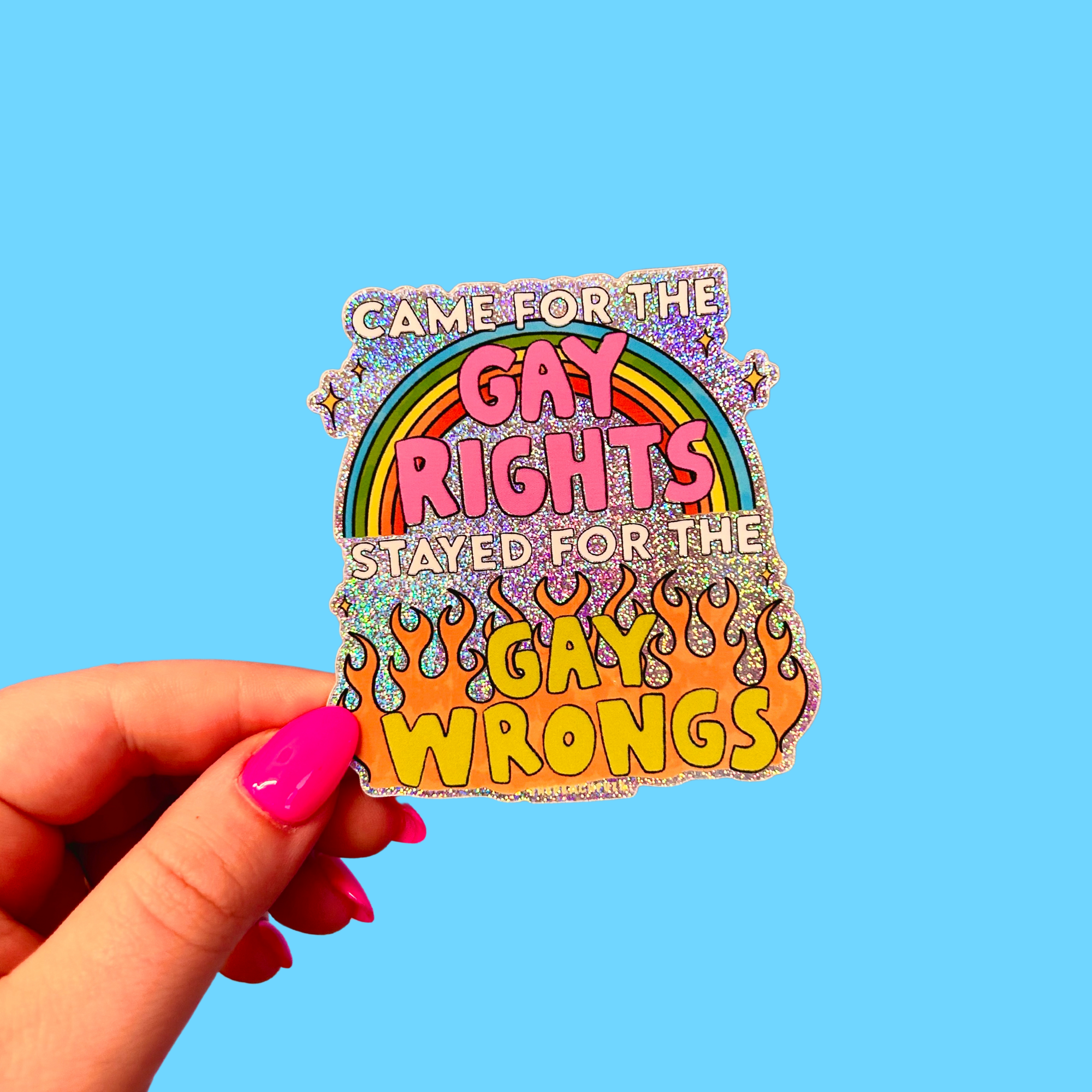Sticker with rainbow design and text held by a hand against a blue background