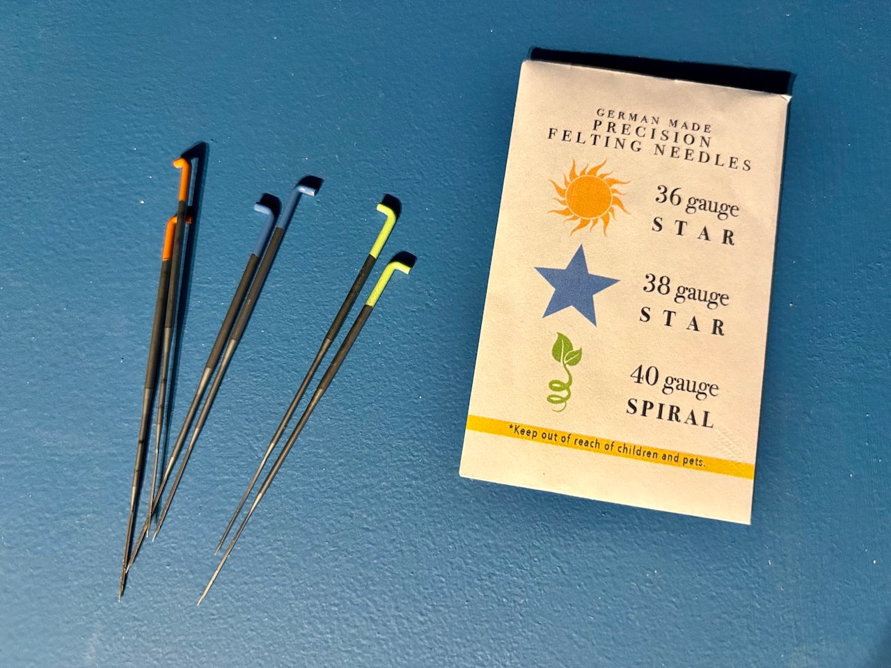 Felting needles with a packaging pouch on a blue background