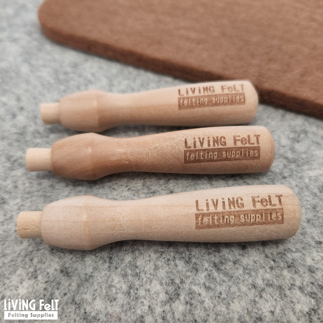 Three wooden needle felting needle holders from Living Felt felting supplies on a gray felt pad 